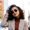 Nadia Ortiz, lead author at Joliely, wearing a checkered coat on a Brooklyn street