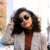 Nadia Ortiz, lead author at Joliely, wearing a checkered coat on a Brooklyn street